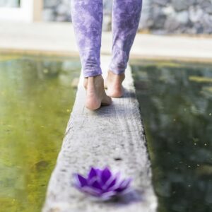 Shot of a purple glass lotus while a woman walks away.