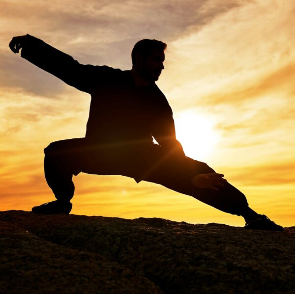 Man, meditation and silhouette, training and tai chi outdoor at a beach, wellness and calm with sun